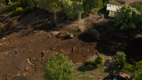 aerial dive bomb and passover perspective of a digger digging into under construction landscape garden