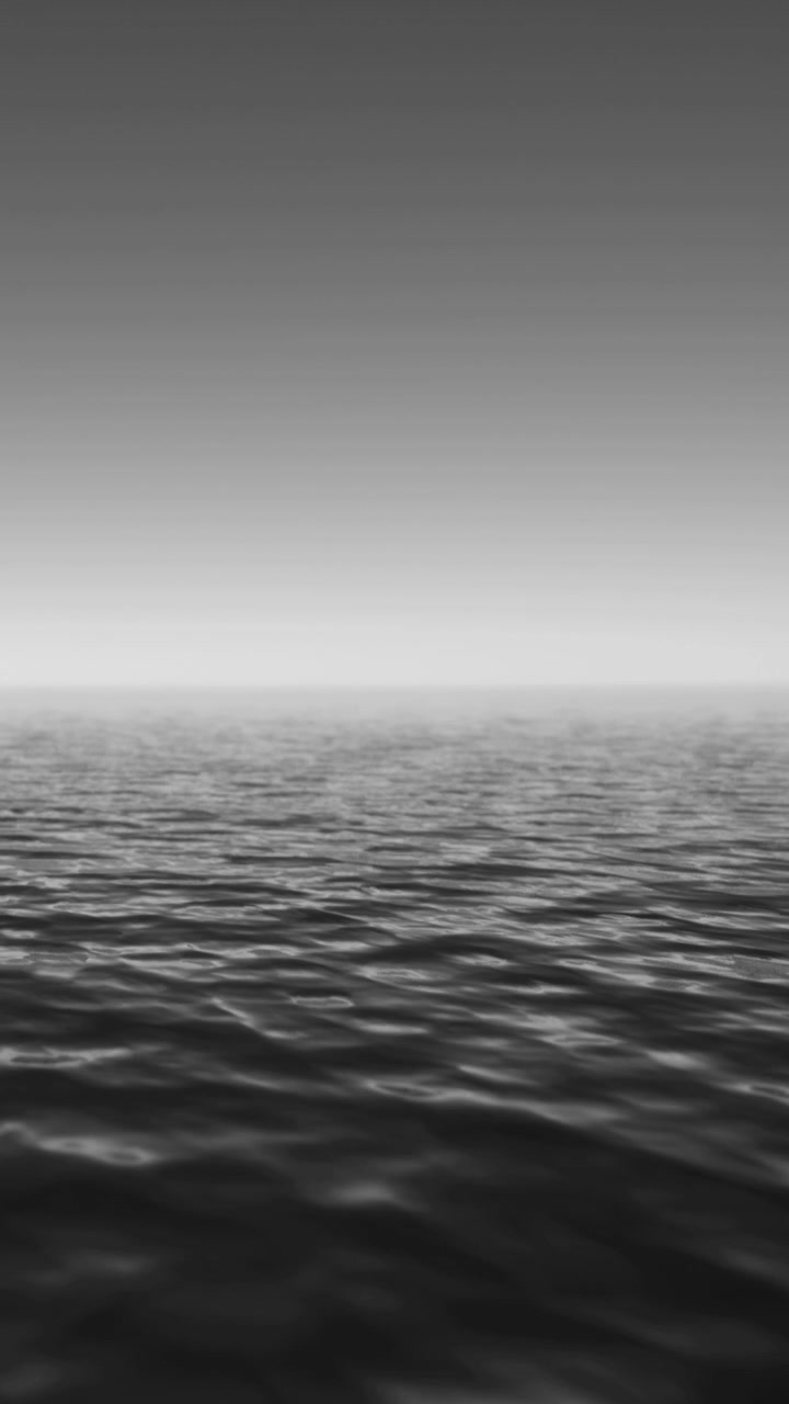 Calm waters stretch to the horizon under a muted sky at dawn
