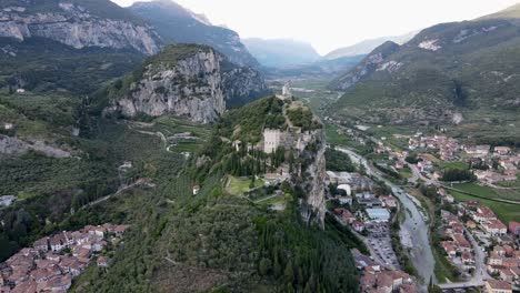 revealing drone shot of castello di arco on a mountain near lake garda, italy