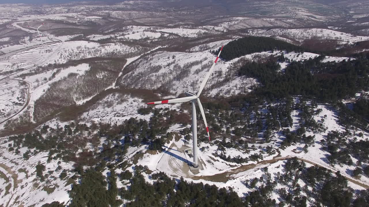 girando alrededor de turbinas de viento en la cima de una montaña