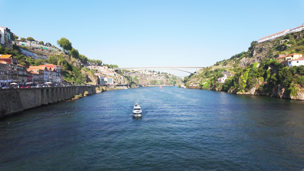 Boat sailing under the Luís I Bridge on the Douro River in Porto on a sunny day
