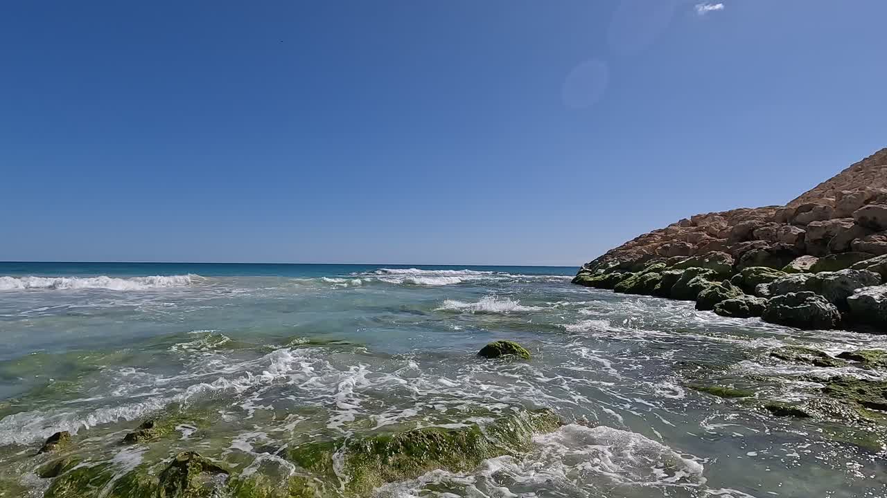 Waves washing over rocky coastline on sunny day at Claytons Beach, Mindarie - Perth