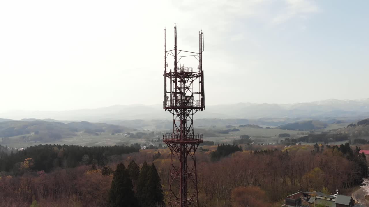 Aerial rotates Radio Tower at Mount Iwaki Japan along Cherry blossom Sakura Trees, Aomori region