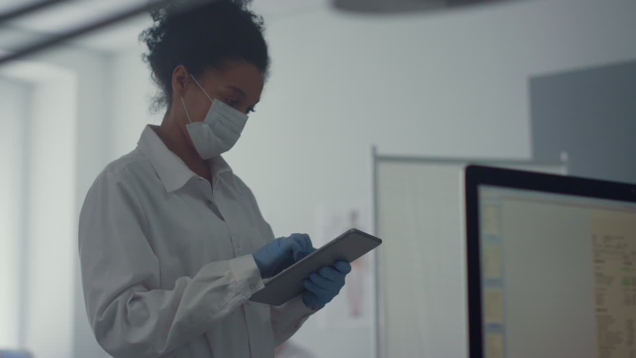 Doctor woman checking analysis results on tablet standing clinic office close up