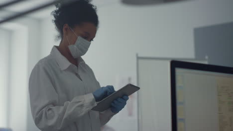 mujer médico comprobando los resultados del análisis en la tableta de pie oficina de la clínica de cerca