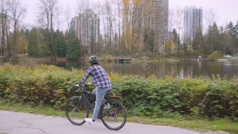 a man is riding his bike around lake lafarge during autumn season.