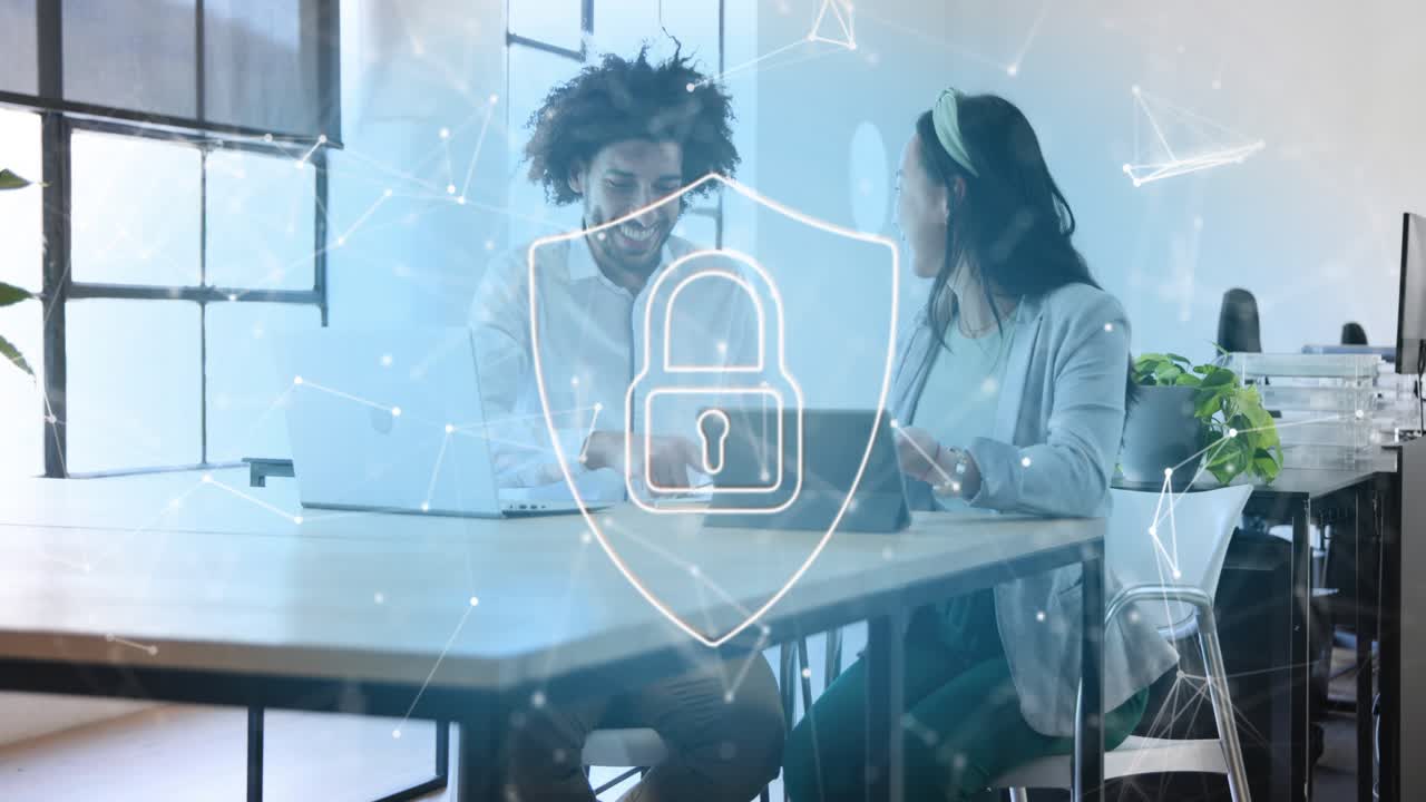 Man and woman reacting to laptop content while discussing, security padlock shield overlaying scene