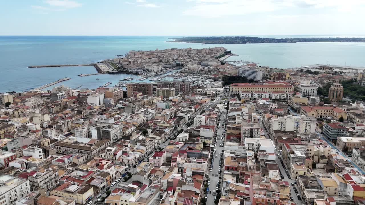 Amplia vista aérea del paisaje urbano de Siracusa en Sicilia. Perspectiva de dron mostrando la densa arquitectura urbana y los edificios residenciales que se extienden hacia la costa mediterránea