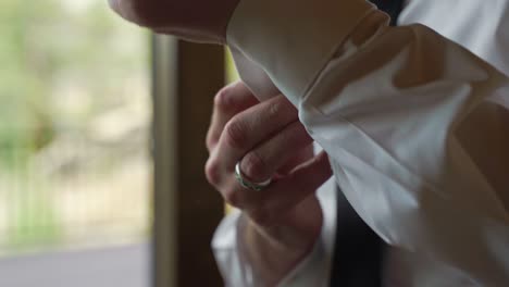 groom in white dress shirt adjusting fixing his sleeve cufflinks