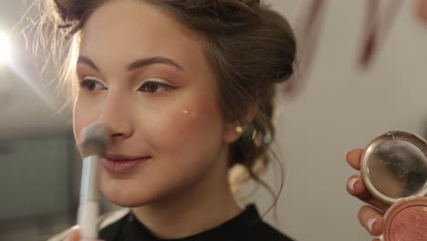a young woman is receiving an expert makeup application, showcasing various techniques and tools commonly used