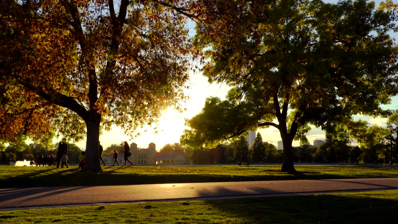 familia caminando en el parque de la ciudad durante la puesta de sol en denver, colorado