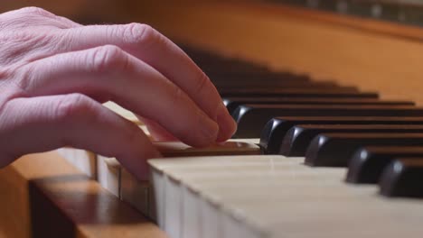 dolly en una mano tocando un acorde en un piano antiguo