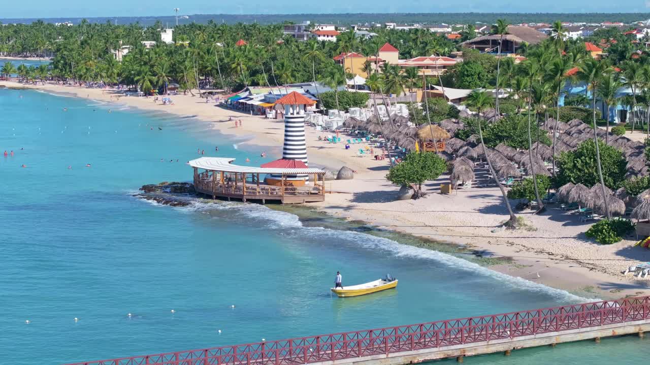 Fisherman on a yellow boat near the lighthouse at Dominicus Beach, Bayahibe, the Dominican Republic. Static drone aerial