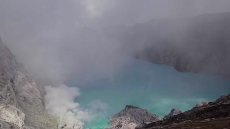 cloud of steam gas from volcanic lake of mount ijen in indonesia - aerial