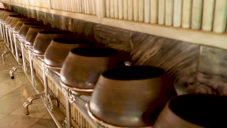 row of alms bowls in wat pho temple