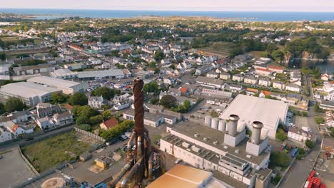 high circling flight over power station with views to the north coast of guernsey showing industry and housing on bright day