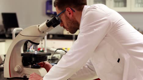 scientist looking through a microscope