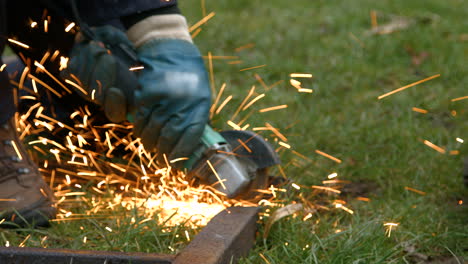 Funken-Fliegen-Auf-Rostigem-Altem-Metall,-Während-Ein-Arbeiter-Mit-Schutzhandschuhen-Und-Overalls-Einen-Winkelschleifer-Bedient