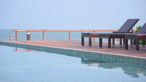 Deckchair-in-front-of-the-sea-and-swimming-pool