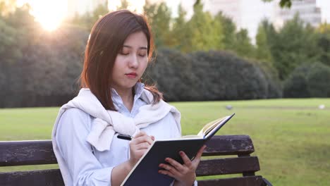 4k:beautiful asian girl reading book at park,shanghai,chin