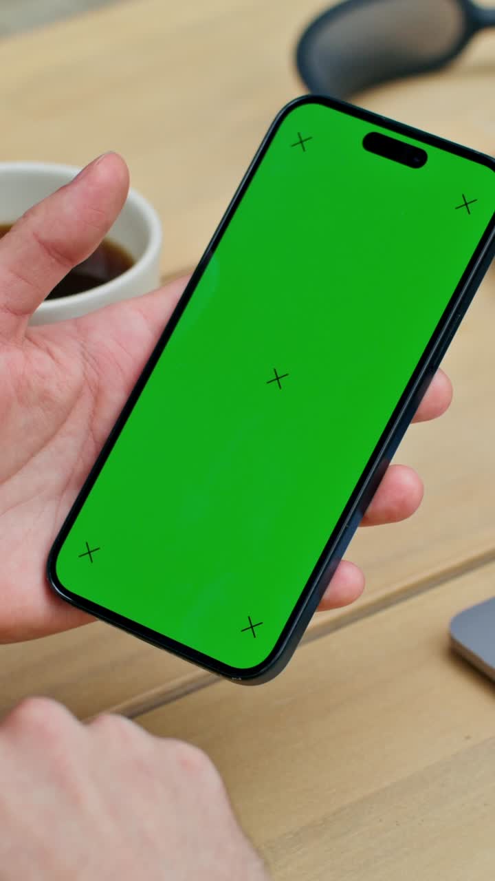 mano sosteniendo un teléfono inteligente con una pantalla verde