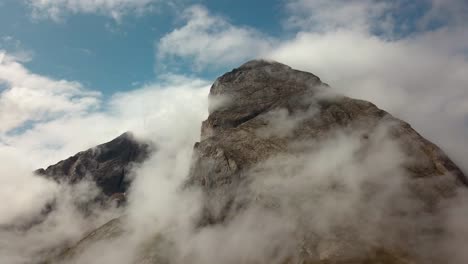 Pico-De-La-Montaña-Rocosa-De-Dolomita-En-El-Norte-De-Italia-Con-Nubes-Frías-Formando-La-Parte-Superior-Durante-La-Temporada-De-Invierno,-Tiro-Aéreo-En-órbita-Lenta