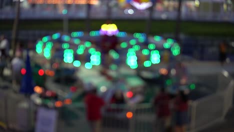 luces brillantes en un paseo en un parque de atracciones local por la noche