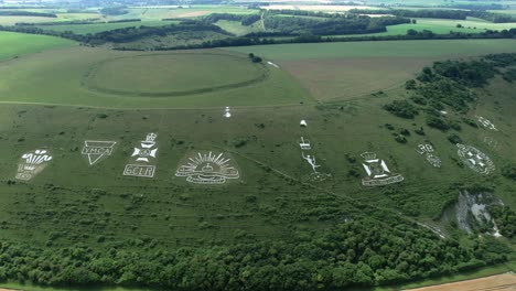 Fovant military badges carved into the Wiltshire chalk hill Orbiting aerial view across green English countryside landmark