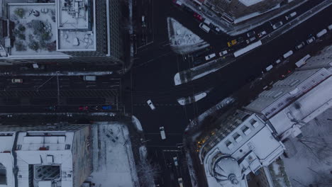 Aerial-birds-eye-overhead-top-down-ascending-view-of-traffic-on-crossroad.-Cars-driving-through-winter-city.-Berlin,-Germany