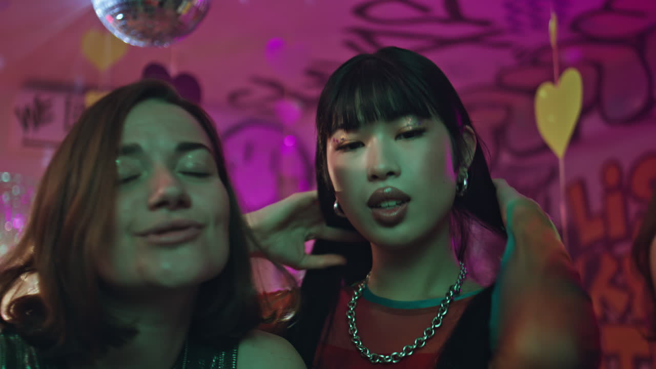 Excited girls dancing hangout in nightclub closeup. Carefree friends night party