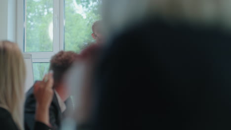 un joven está hablando en una conferencia de negocios. retrato cerca de las listas. los colegas están aplaudiendo.