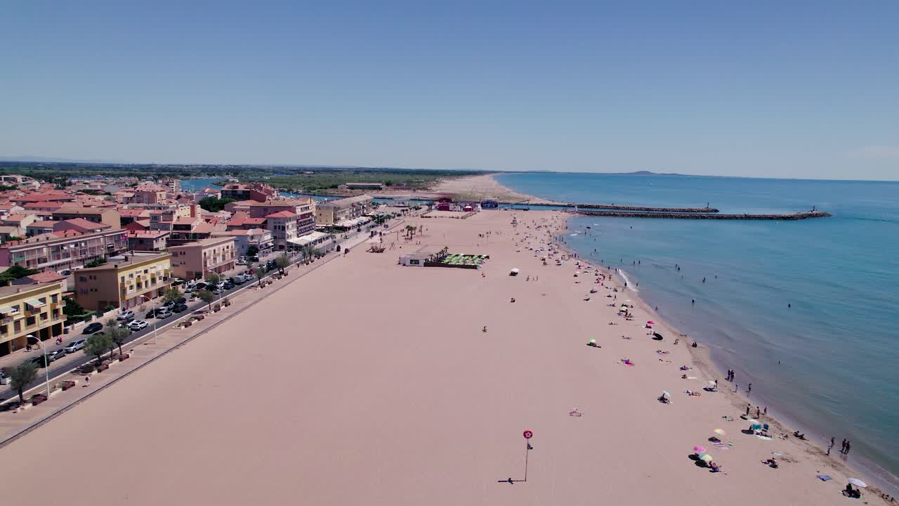 Una bellissima spiaggia in una giornata di sole con cielo blu e persone che si godono il momento.