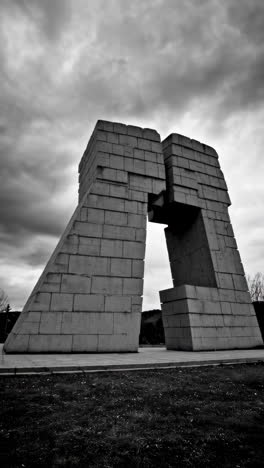 brutalist concrete monument under a dramatic sky