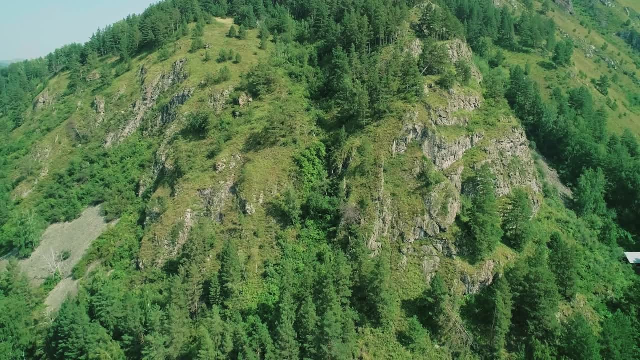 vista aérea de la montaña verde con formaciones rocosas y árboles.
