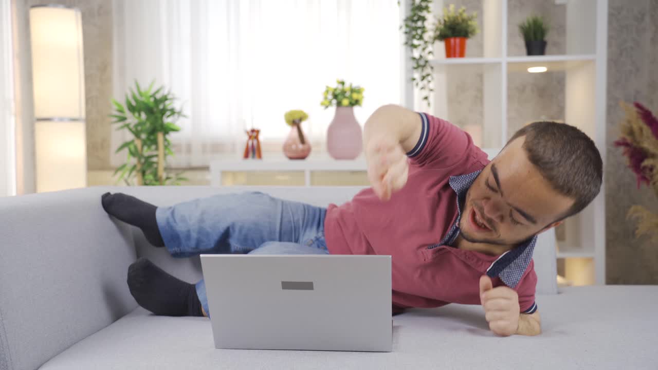 집에서 노트북으로 온라인으로 일하는 난쟁이가 기 ⁇ 하고 웃고 있습니다.