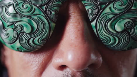 close-up of man wearing ornate jade sunglasses