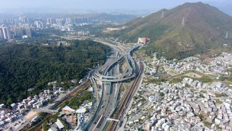 Verkehr-Auf-Einem-Massiven-Autobahnkreuz-Mit-Mehreren-Ebenen-Und-Schleifenförmiger-Straße-In-Hongkong,-Luftbild