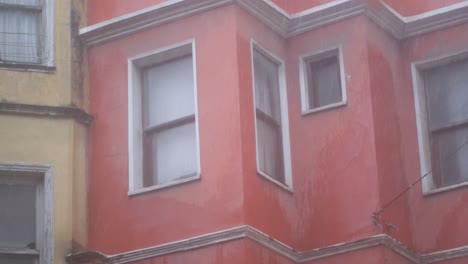 pink building corner on a rainy day
