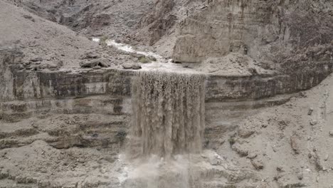 Potente-Primer-Plano-Aéreo-De-Una-Cascada,-Desierto-Israelí,-Agua-De-Inundación-Después-De-La-Lluvia,-Disparo-De-Drone-Extraíble