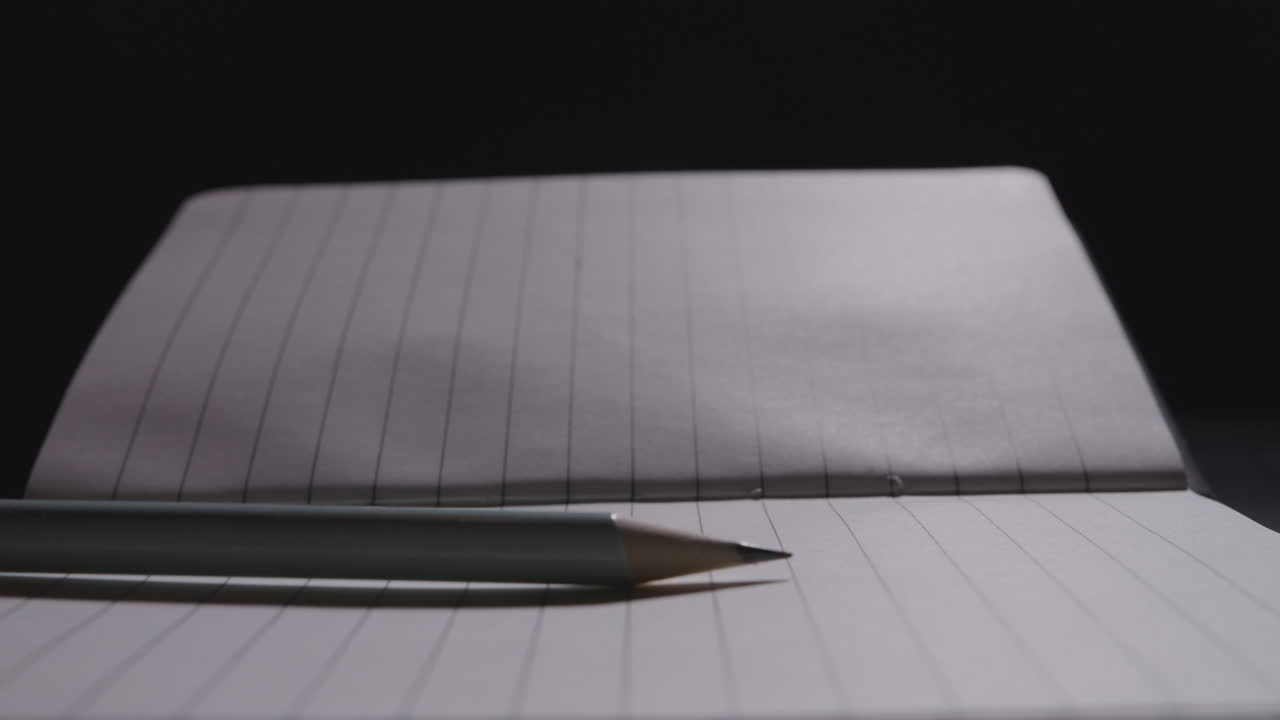 Close up of pencil slamming on the notebook