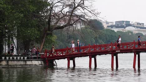 gente cruzando un puente rojo en hanoi, vietnam