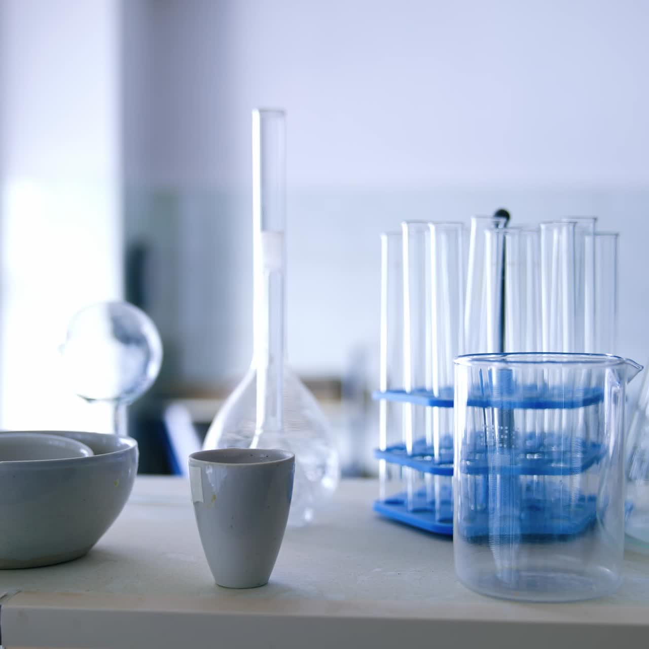 Vetreria per esperimenti di laboratorio scientifico. Bicchieri e fiasche sulla scrivania. Sfondo sfocato