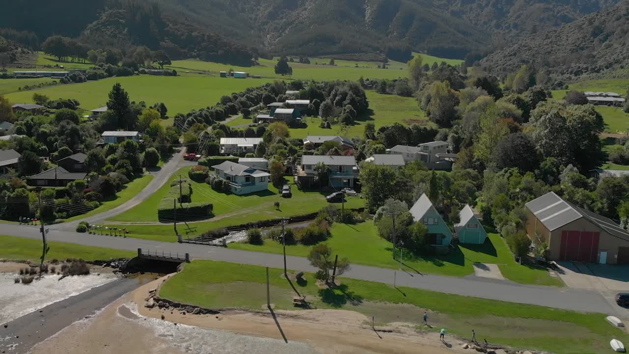 toma aérea de la ciudad de anakiwa por playa, sonido de la reina charlotte, sonidos de marlborough, isla del sur, nueva zelanda
