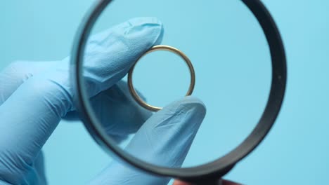 examining a gold ring under a magnifying glass