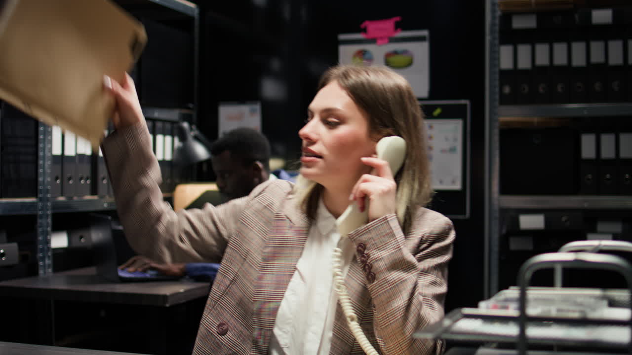 Businesswoman in office talking on the phone and working on documents