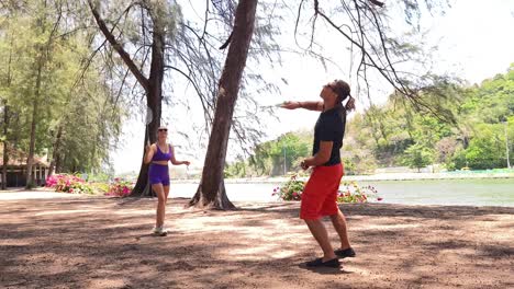 couple playing badminton by the lake
