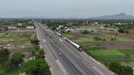 Toma-Aérea-De-Un-Camión-Que-Transportaba-Un-Molino-De-Viento-En-La-Carretera.