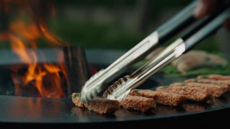 Unknown-man-preparing-meat-kebab-on-grill-on-backyard.-Man-chef-using-forceps