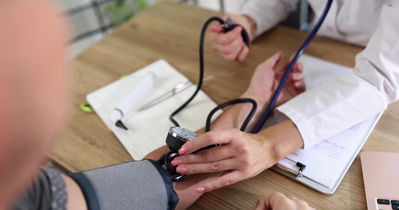 Il medico misura la pressione al paziente, al rallentatore.