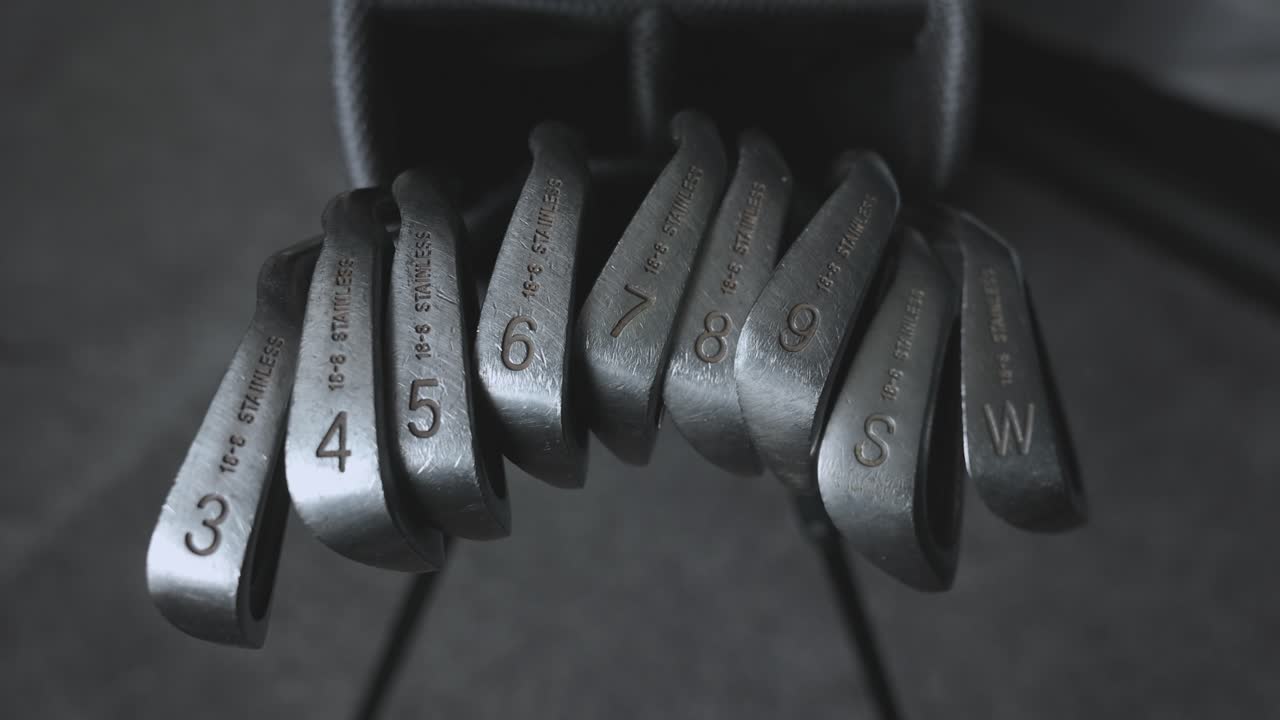 static shot of various metal clubs within a golfers bag